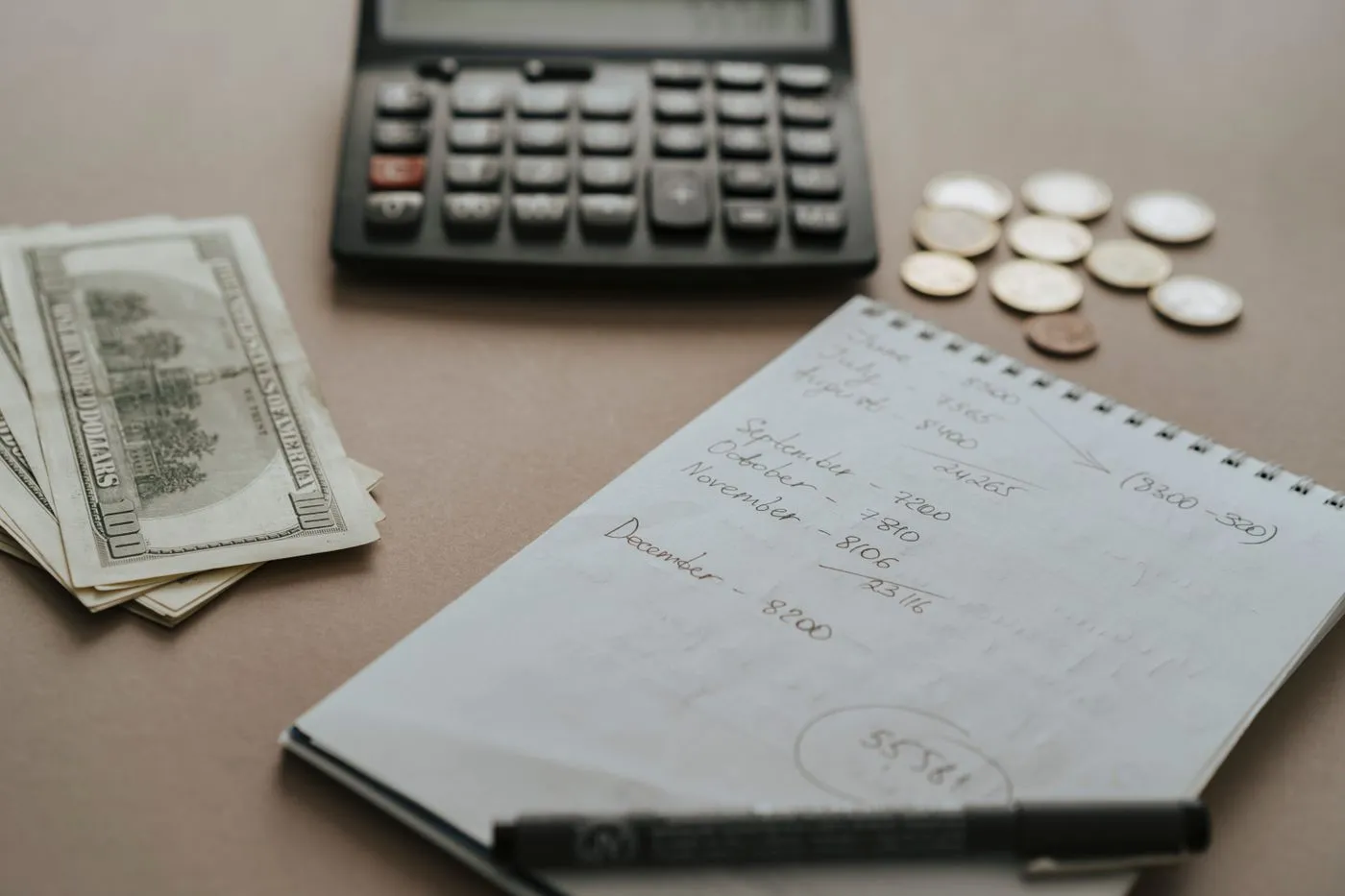 Calculator, cash and budget notes on a desk