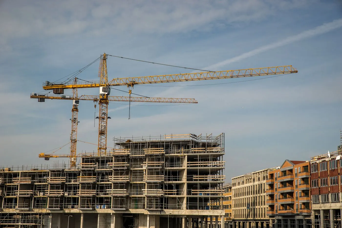 Mid-rise building under construction with tower cranes