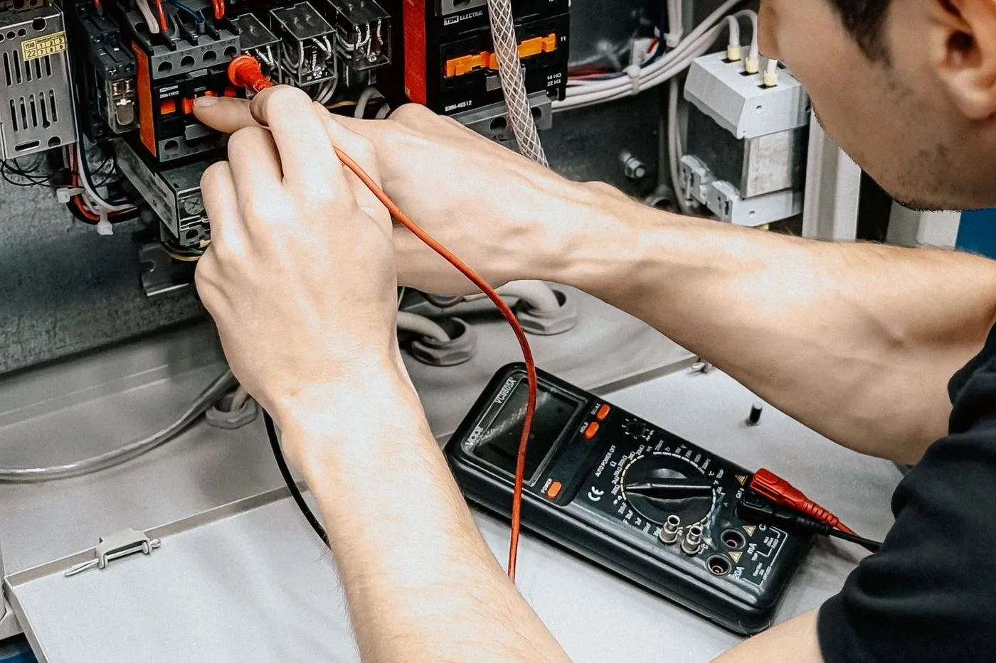 Electrician testing an electrical panel with a multimeter