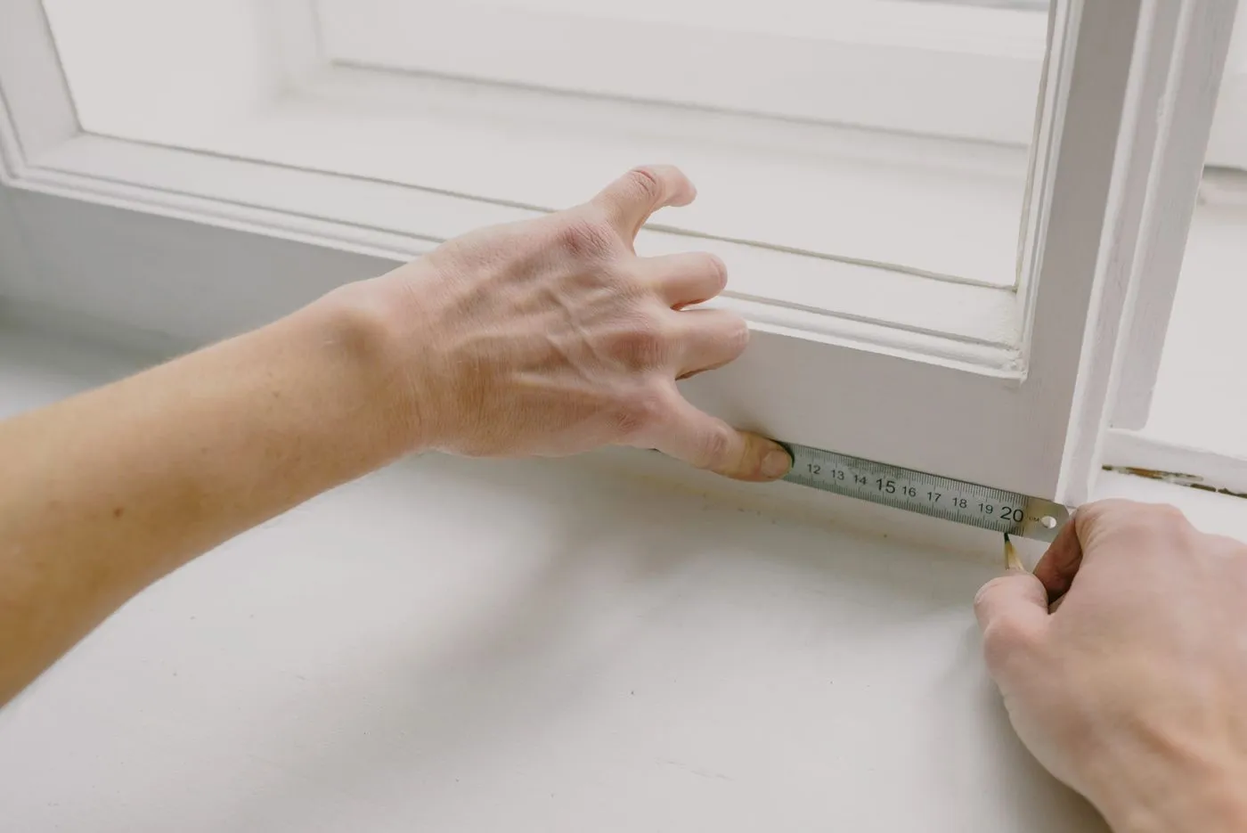Carpenter measuring trim with a tape measure