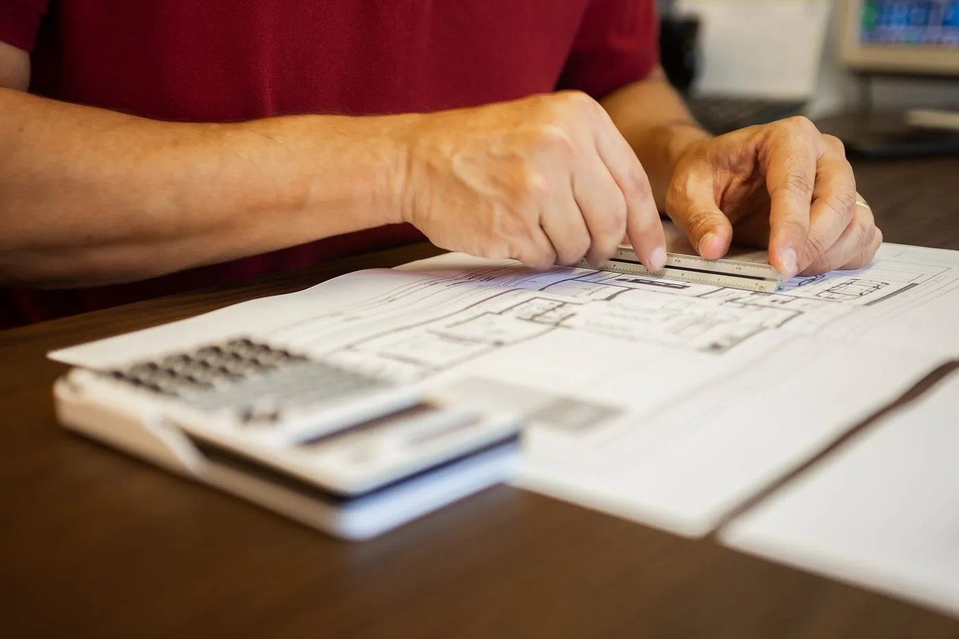 Estimator checking a plan sheet with a calculator