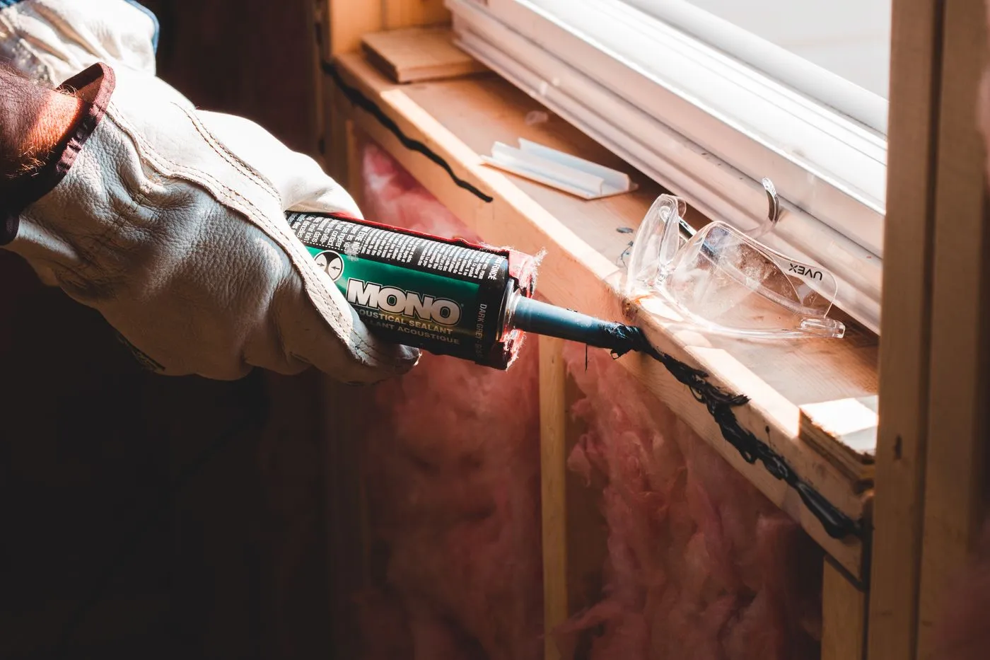 Worker sealing a window joint with sealant