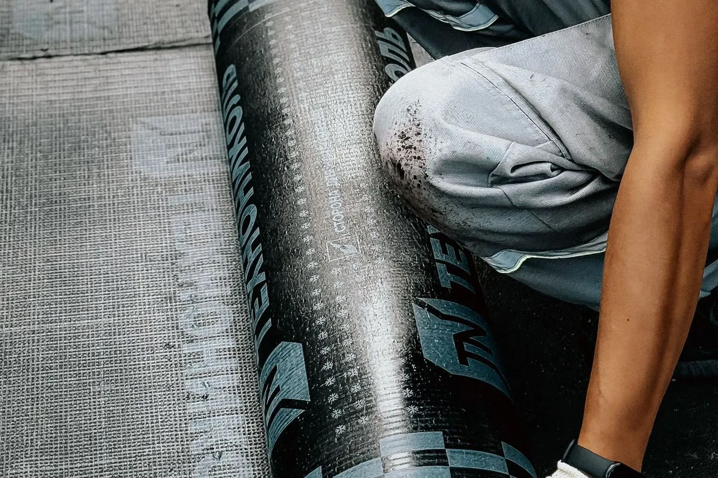 Worker installing a waterproof membrane